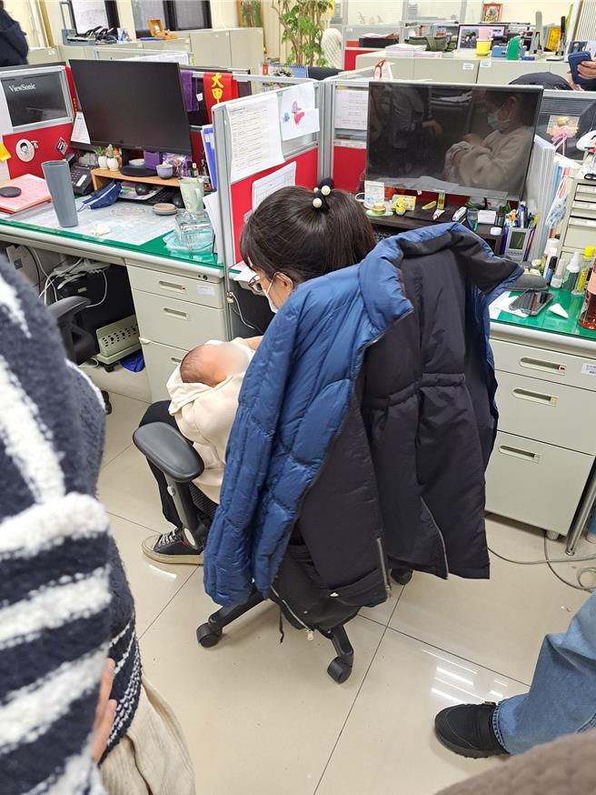 妇幼队警员曾英绫冲泡奶粉喂食飢肠辘辘的新生儿，热心同仁在旁协助。（台中市警察局提供）