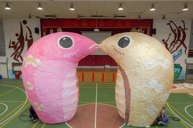  12日十分场主灯呼应西洋情人节，首次设计12呎蛇年双心天灯kiss，在金蛇与粉红蛇双蛇天灯併拢下形成巨大爱心kiss。（新北市观旅局提供）