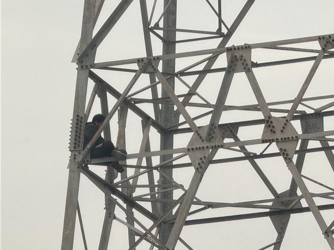 台中市龙井区沙田路四段某处电塔，6日上午8时多传出1名男子沿着铁杆，一路爬上电塔约3分之1处，警消获报赶往现场劝导，并铺起气垫防护。（潘虹恩摄）