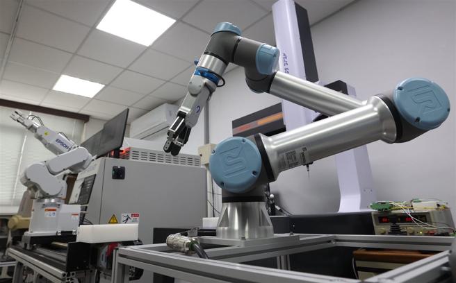 走进「智慧工厂」，映入眼帘的是传统六轴机械手臂，以及结合最新AI人工智慧的「协作型机械手臂」（右）。（记者黄迪明摄）