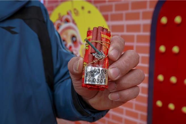 后龙镇慈云宫元宵节活动，副主委郭金发表示每个鞭炮都贴上防热贴纸，掷中小城门的民眾可凭号码兑换奖品。号码贴纸可在庙内服务台购买，每张150元，内含50个号码，吸引民眾参与庆祝活动。（吕丽甄摄）