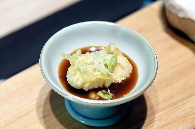 台中「龙富天妇罗」的「白子天妇罗」，是以乌鱼鳔取代鳕鱼白子再裹上厚麵糊油炸，并以红烧酱汁、酥炸蒜苗搭配提味。图／姚舜