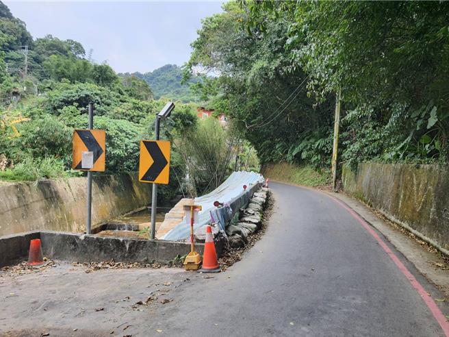 施工前邊坡滑落以鼎塊補強且堤頂僅單車道，造成會車困難。（水利局提供）