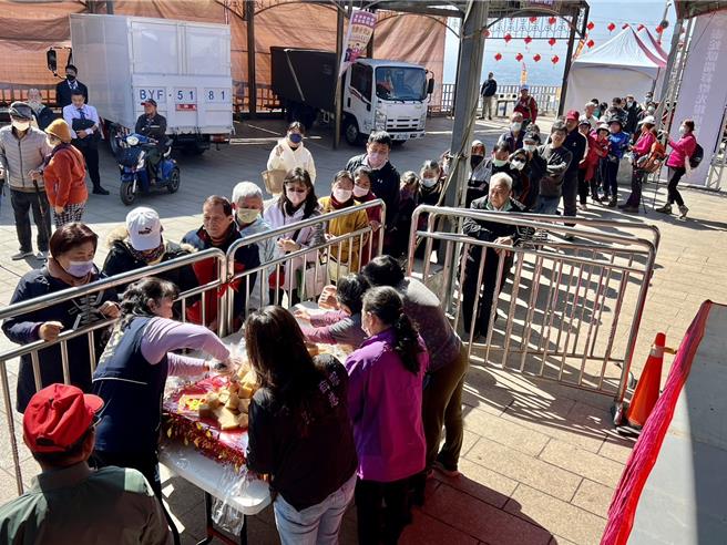 松柏岭受天宫「米糕桃赐平安」记者会后分享米糕，吸引大批信眾排队领取。（杨静茹摄）