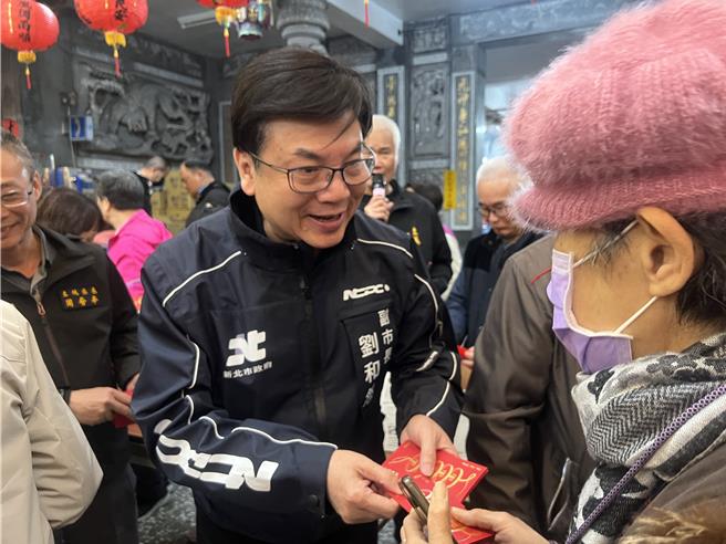 刘和然带着市府的福袋发送给民眾。（吕健豪摄）