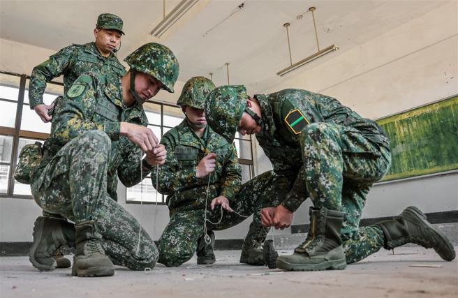 教官傳授運用現地素材進行簡易詭雷爆破設置，形成多重阻絕，以達到遲滯敵人行動的目的。（記者謝承宏攝）