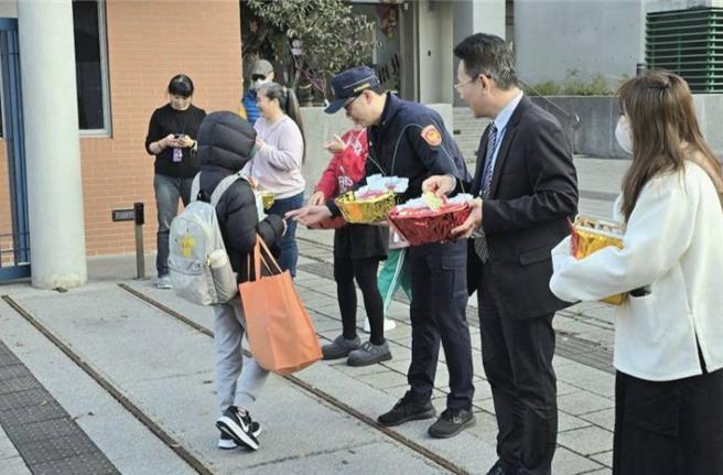 南港分局長周哲民率員警至東新國小守護學童安全，並與校長李家旭共同發放新春小禮品給學童們。(翻攝照片／林郁平台北傳真）