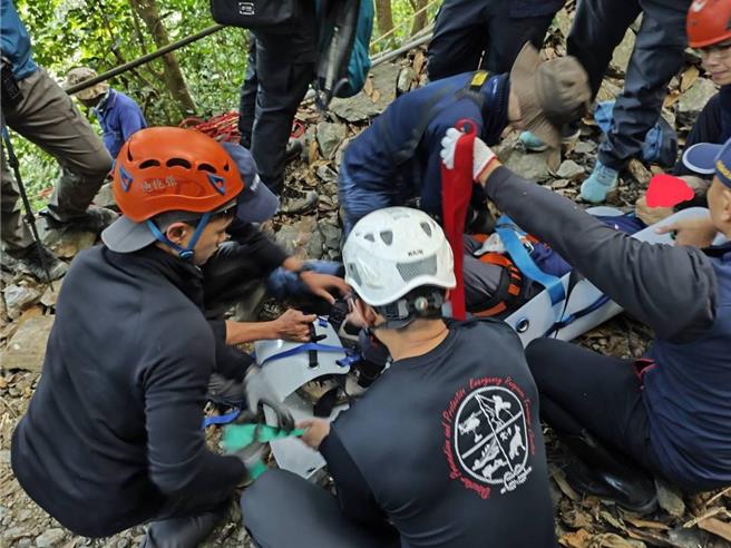 搜救人员以担架将许翁抬下山。（屏东县消防局提供／罗琦文屏东传真）