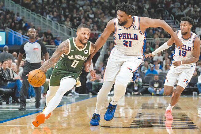 利拉德（左）运球突破恩比德的贴身防守。（路透）