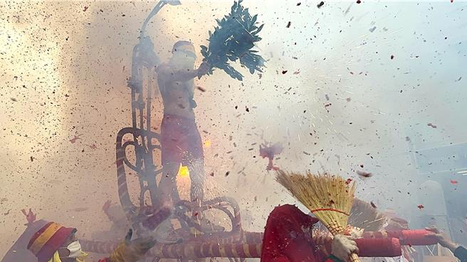 肉身寒单手持榕叶昂然登轿，迎接四面八方而来的鞭炮。（民眾提供／萧嘉蕙台东传真）