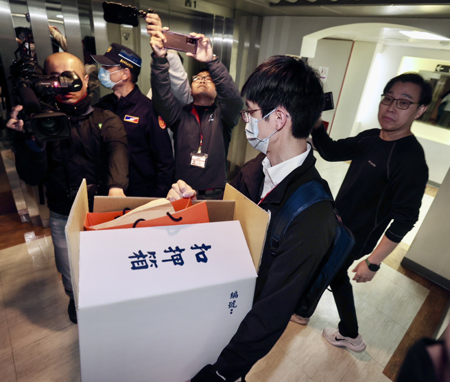 民进党台北市议员陈怡君议员研究室12日遭检调搜索，陈并遭检调人员带离；图为检调人员带着扣押箱离开议员研究室。（郭吉铨摄）
