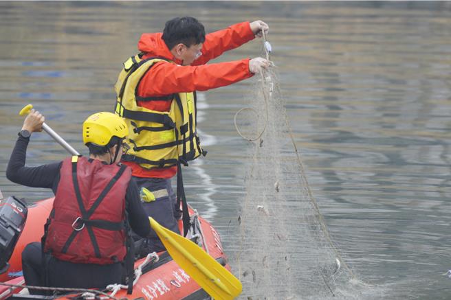 今日高雄下起雨势，酿前镇河中几乎无能见度，因此不会派潜水员下水搜索，以河面、河岸打捞为主。（任义宇摄）
