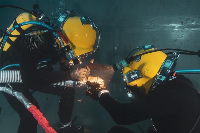 海軍水下作業大隊「水械專長班115期」昨日進行水面供氣組合訓練，學員搭乘潛水鐘下潛至訓練池底，模擬在海底執行搜索及障礙排除作業，深化水下作業職能。（記者謝承宏攝）