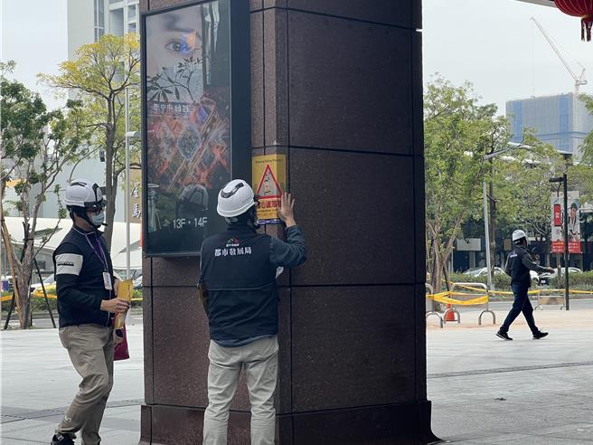 台中新光三越无限期停业，台中市府派员在周边张贴危险告示。（林欣仪摄）