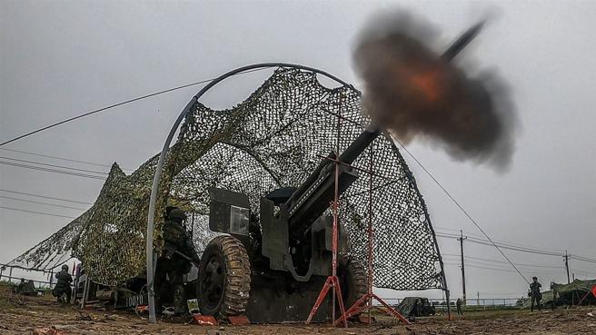  「预备，放！」红旗落下的瞬间，发射手立即拉动火绳，炮弹迅速出膛飞向空中，发扬炮兵炽盛火力。
（记者林睿奕摄）