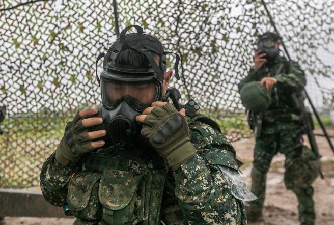  听闻毒气警报器声响，官兵迅速佩戴防护面具，并接续校正火炮参数及射击任务，展现紧急应变能力。
（记者林睿奕摄）