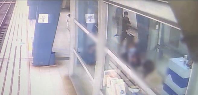 婦人在月台候車室煎鍋貼，站務員到場勸阻。（民眾提供）