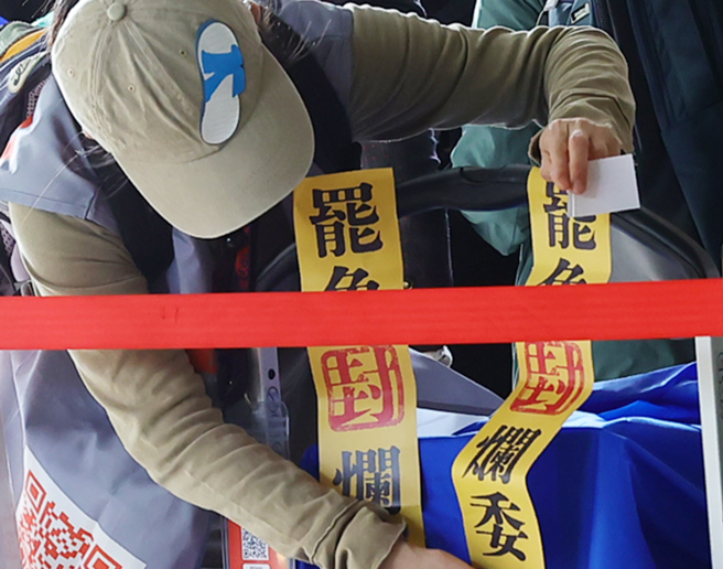 大罢免潮遍地开花，国民党日前也宣布推动「反戒严、反废死」公投意图反制。图为罢免团体工作人员在载运资料的推车上贴着罢免烂委的封条。（资料照／刘宗龙摄）