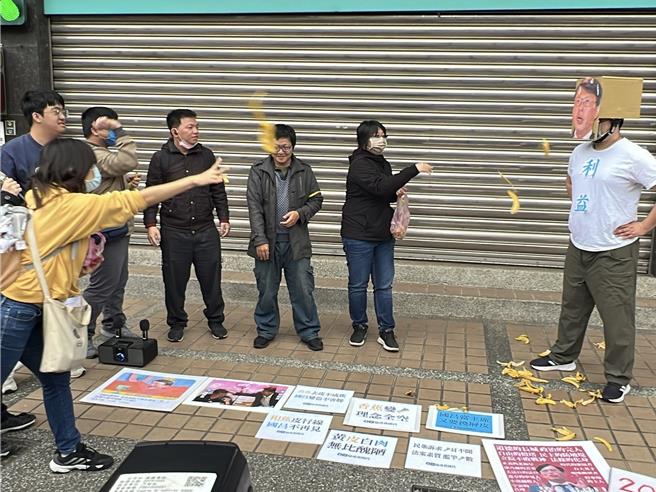 「协寻黄国昌」公民团体在黄国昌板桥服务处前上演行动剧，朝黄国昌扮演者丢掷香蕉皮。（王扬杰摄）