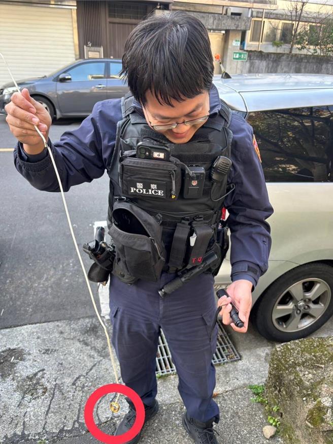 員警用衣架將掉入水溝的戒指勾出。（警方提供）