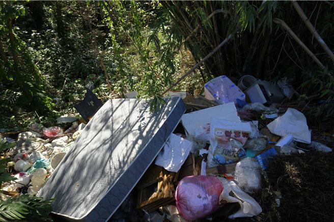 2025年1月18日苗栗县／苗栗县头份市尖东产业道路沿线近日惊见大量垃圾被弃置，包括废弃家具、马桶、木板、家庭垃圾及床垫等物品，环境遭严重破坏。警方接获报案后迅速介入调查，成功锁定涉案男子，并依法送交环保局裁罚。（吕丽甄摄）