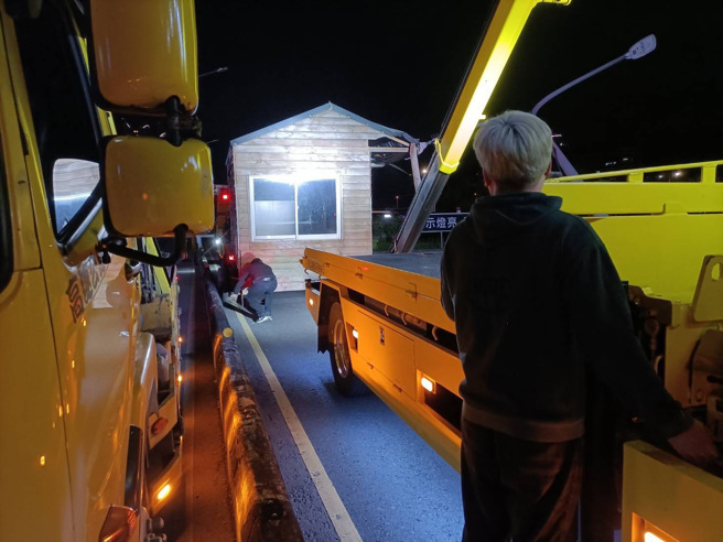 拖吊车拖引挂轮的小木屋，行经新店环河路，驾驶没注意小木屋超宽，撞击灯杆后当场变成「在地木屋」，最强钉子户。（翻摄画面）