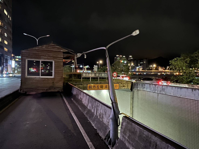 拖吊车拖引挂轮的小木屋，行经新店环河路，驾驶没注意小木屋超宽，撞击灯杆后当场变成「在地木屋」，最强钉子户。（翻摄画面）