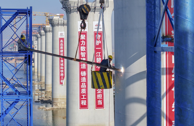 在江苏省淮安市金湖县淮河入江水道寧淮城际铁路施工现场，工作人员在进行焊接作业。（新华社）
