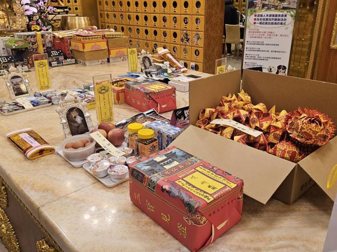 家人帶愛犬妮娜最愛吃的肉肉和罐罐來祭拜。(飼主蔡小姐提供)