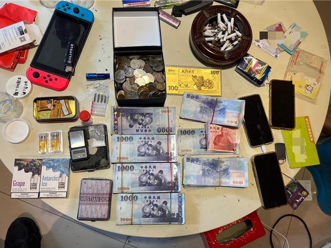 大笔现金赃款堆放置车手藏匿处所的桌上，另外还有毒品等违禁品。（警方提供）