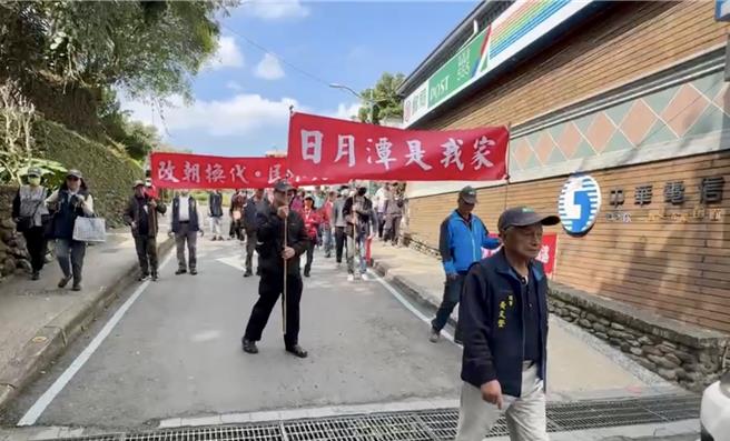 日月潭土地正义学会高举「改朝换代、民不失土」等旗帜，从梅荷园徒步至水社码头。（杨静茹摄）
