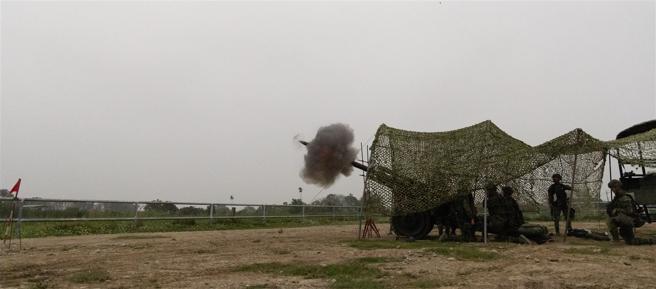 射击口令下达，炮弹瞬间射向目标区，充分展现炮班成员高度默契与连日精实训练成果。（记者尤韵婷摄）