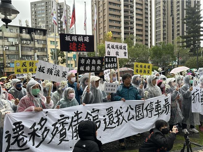 成员手持告别式常用的「菊花」象徵哀悼新北殡葬政策之意。（高钧麟摄）