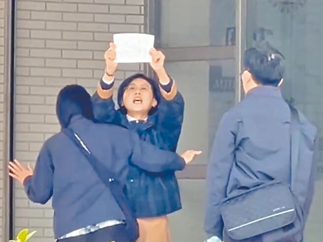 民进党立委林岱桦20日被带回调查局南机站时，高举字条大喊「政治干预司法，司法干预初选」。（民眾提供／郭良杰高雄传真）