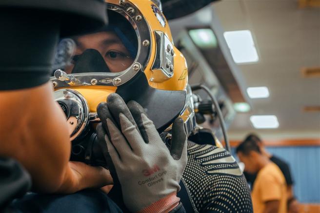  助手協助潛水員著裝，確保訓練遂行。（記者陳怡璿攝）