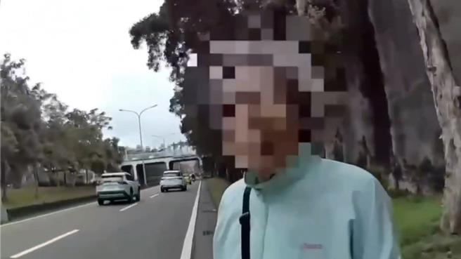 楊姓老婦獨自走在快車道上，警方趕緊將她帶到路邊。(翻攝照片／林郁平台北傳真）