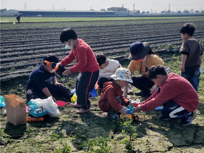 小孩挖土。（周丽兰摄）