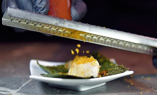 「青杉烧肉」的「炭烤干贝」，在将干贝烤至半生熟后，会现刨乌鱼子粉末提味，吃时再用海苔包卷入口。图／姚舜