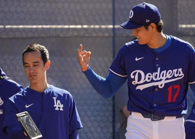道奇投手大谷翔平一边练投一边监控数据。（美联社）