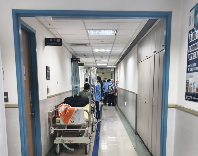 一名急診醫師預言，衛福部開會討論急診雍塞問題，只是官員們去打招呼，然後要求各醫院落實調控床位。圖為台大醫院急診室內人滿為患床都放到走廊。（資料照）