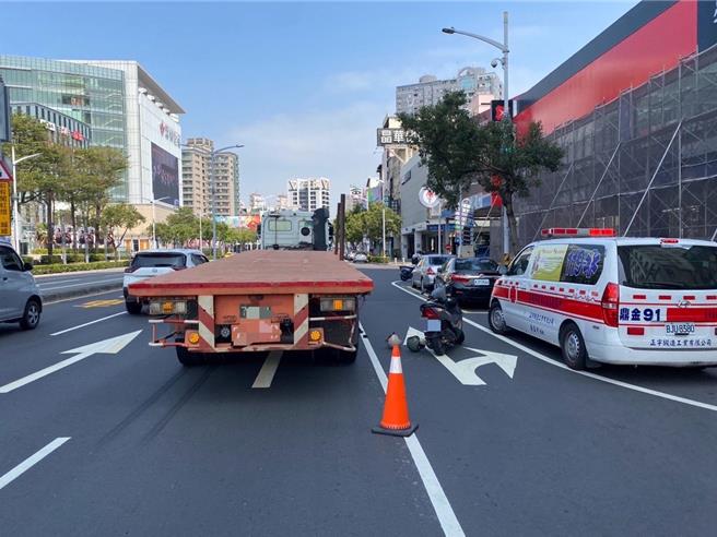 32岁女骑士在巨蛋前遭曳引拖板车擦撞倒地，险遭卷入车底让后方车辆急闪避，幸仅轻伤送医。（警方提供／任义宇高雄传真）
