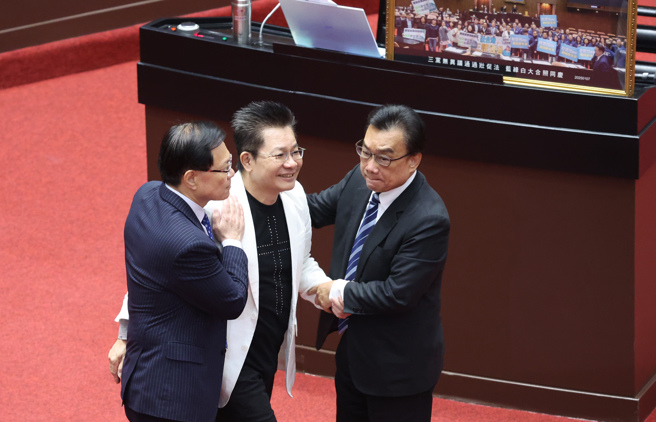 立委吳春城（左二）在25日總質詢中澄清壯世代爭議，並請辭立委一職，同黨立委張啟楷（左）、林國成（右）上前與他握手致意。（姚志平攝）