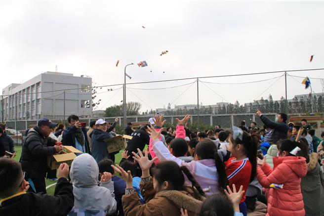 澎湖县湖西乡西溪国小的人工草皮足球场，25日启用，并同时举行国中小班际足球锦标赛。在掷吉仪式上，主办单位用零食替代炸枣、麻糬，让小学生抢翻。（许逸民摄）