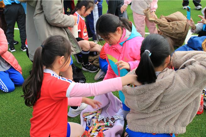 澎湖县湖西乡西溪国小的人工草皮足球场，25日启用，并以零食来掷吉，让小学生捡到乐翻，口袋都不够装，还解下外套当袋子装。（许逸民摄）