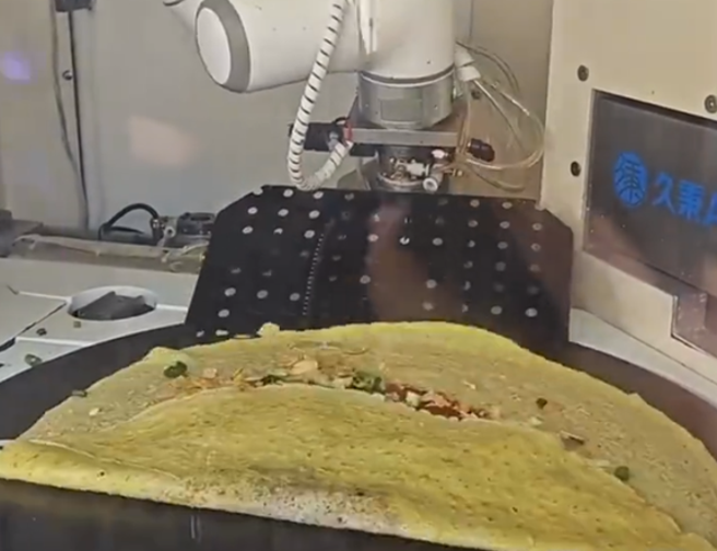 煎饼馃子机器人模仿人类摊麵糊、翻面、加料到卷饼的动作，凝聚了100多项智慧财产权、上万个零部件以及长达8年的研发与打磨，让人怀疑这一份得卖多少钱。（图／快科技）