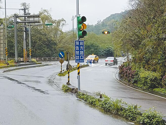 民眾陳情開車行經基隆市七堵區大華二路右彎後馬上就碰到紅綠燈，駕駛常煞車不及衝出停止線，市府在右彎前增設預告號誌提醒用路人減速。（張志康攝）