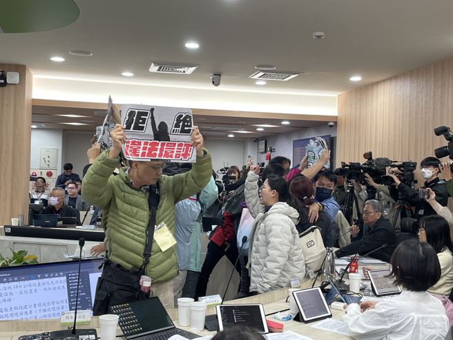 环团不满台电隐匿资料，衝上主席台前高喊散会。（蔡佩珈摄）