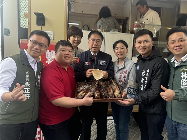 台南市长黄伟哲拿着虾饼冰淇淋与业者捧着龙虾，都是古都马当天的补给品。(曹婷婷摄)