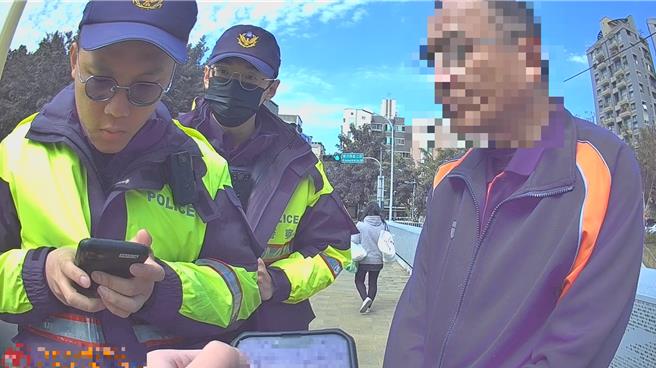 警員耐心詢問路倒男的身分與家屬資料，試著幫他找到住處。（民眾提供／寶智華台中傳真）