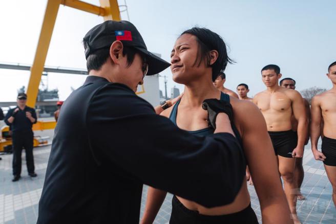 上一位女性學員任婕親手於胸口釘上「金龍徽章」。（軍聞社提供）